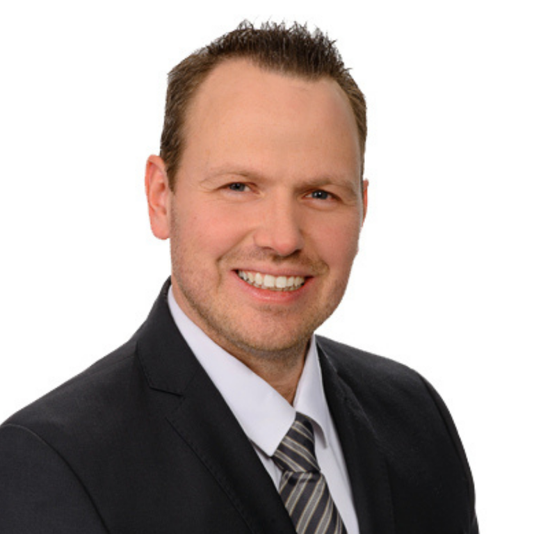 Unser 1. Vorsitzender Patrick Prell Lächelnder Mann (Patrick Prell, 1. Vorsitzender des Ortsverbands) im Anzug mit Krawatte vor hellem Hintergrund.